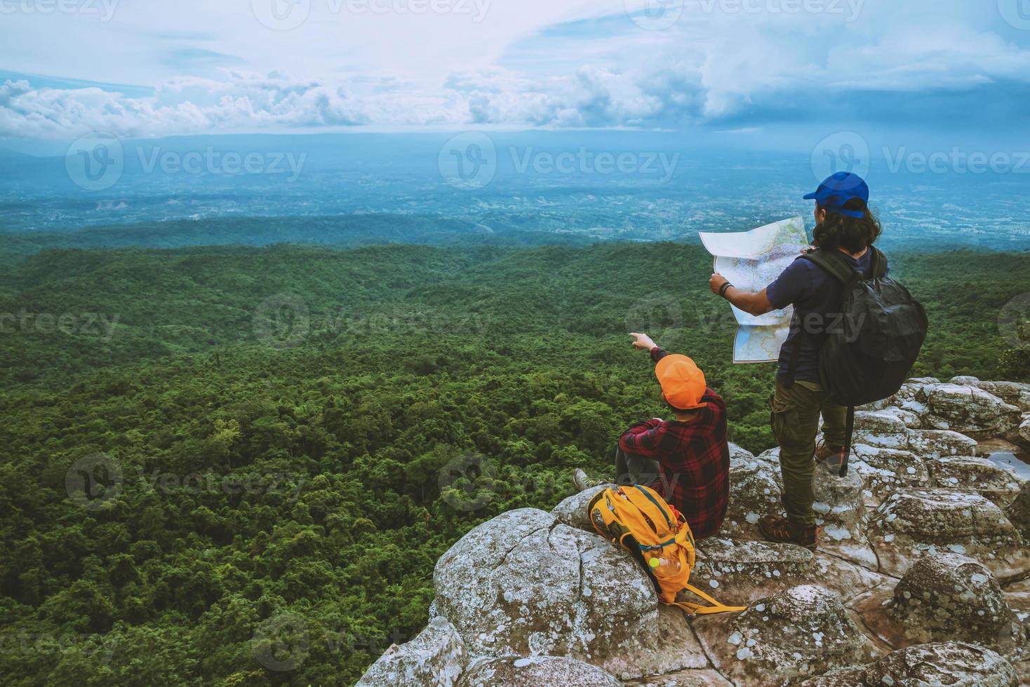 amante donna e uomini asiatici viaggiano rilassarsi in vacanza. guarda la mappa esplora le montagne foto