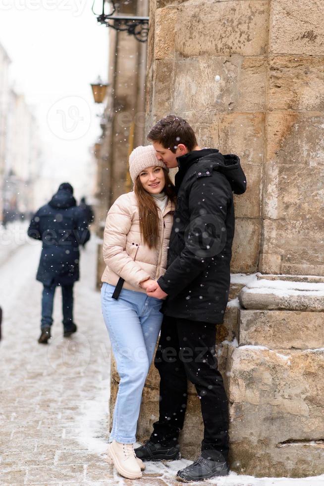 giovane ragazzo e ragazza in abbigliamento invernale godendo di nevicate foto