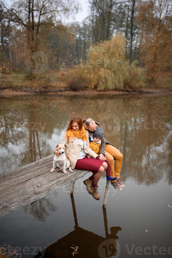 famiglia che si rilassa al chiuso e accarezza il cane foto