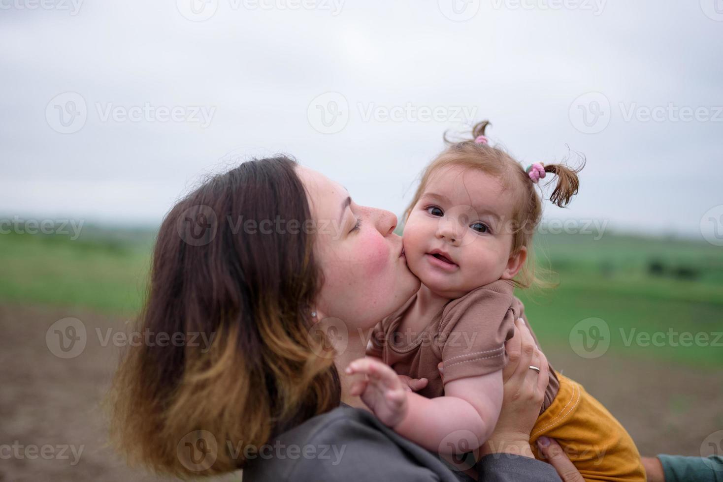 mamma, papà e figlia. i genitori tengono il bambino per mano e vanno verso la telecamera. foto