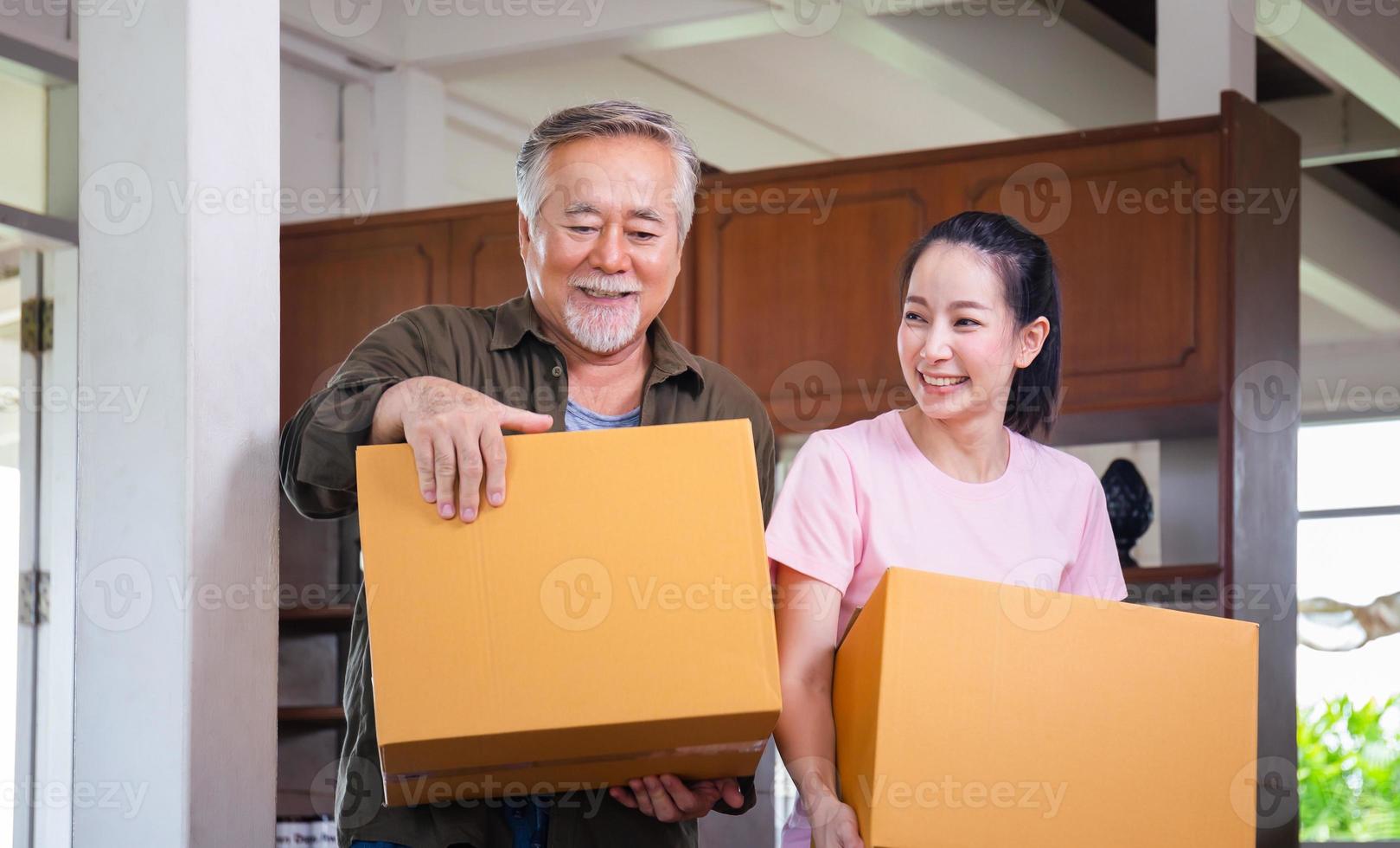 concetti di giorno in movimento, famiglia asiatica che trasporta scatole nella nuova casa, felicità figlia di mezza età e padre anziano nella nuova casa foto