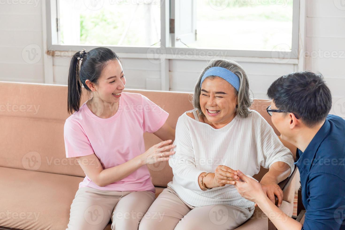 famiglia asiatica attenta che si siede in soggiorno, madre anziana e figlio e figlia di mezza età, concetti di famiglia di felicità foto