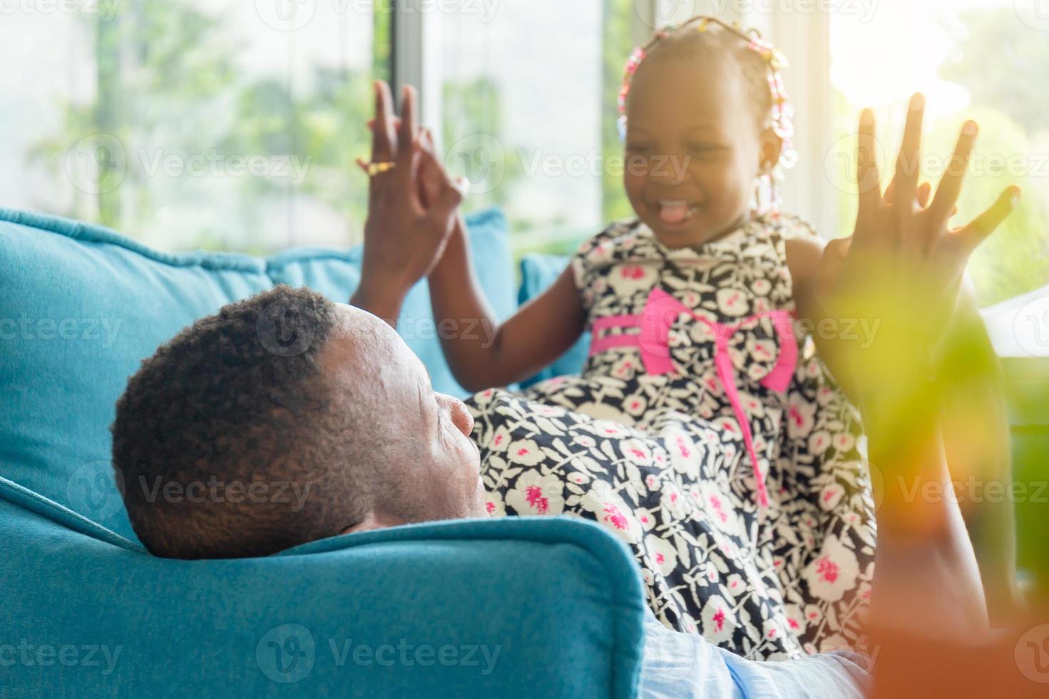 allegro padre e figlia afroamericani che giocano in soggiorno, concetto di famiglia di felicità foto