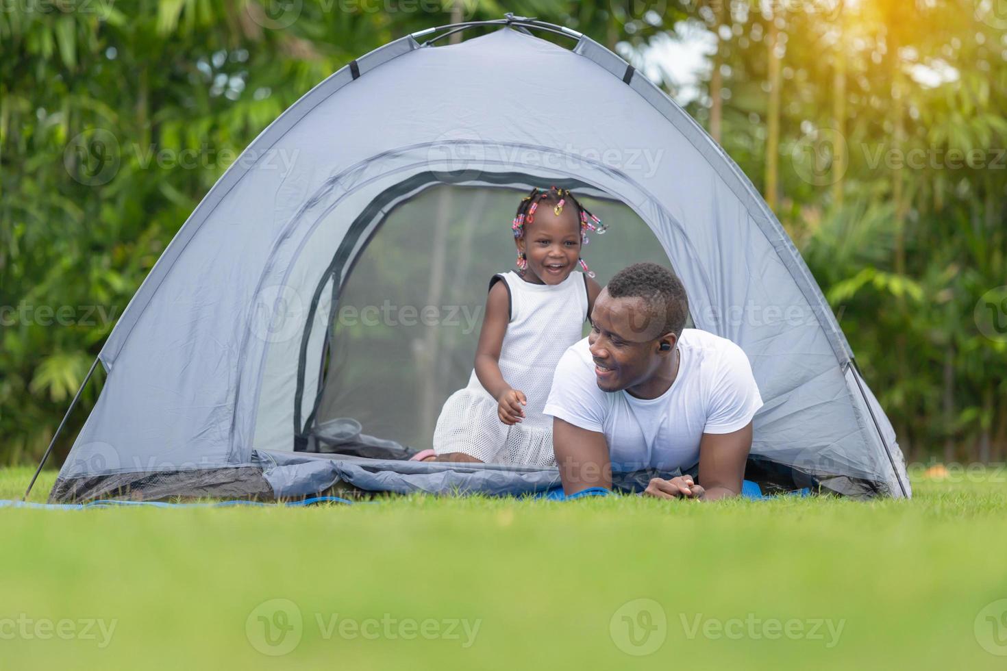 padre felice che gioca con la figlia, ragazza afroamericana allegra che gioca con suo padre foto
