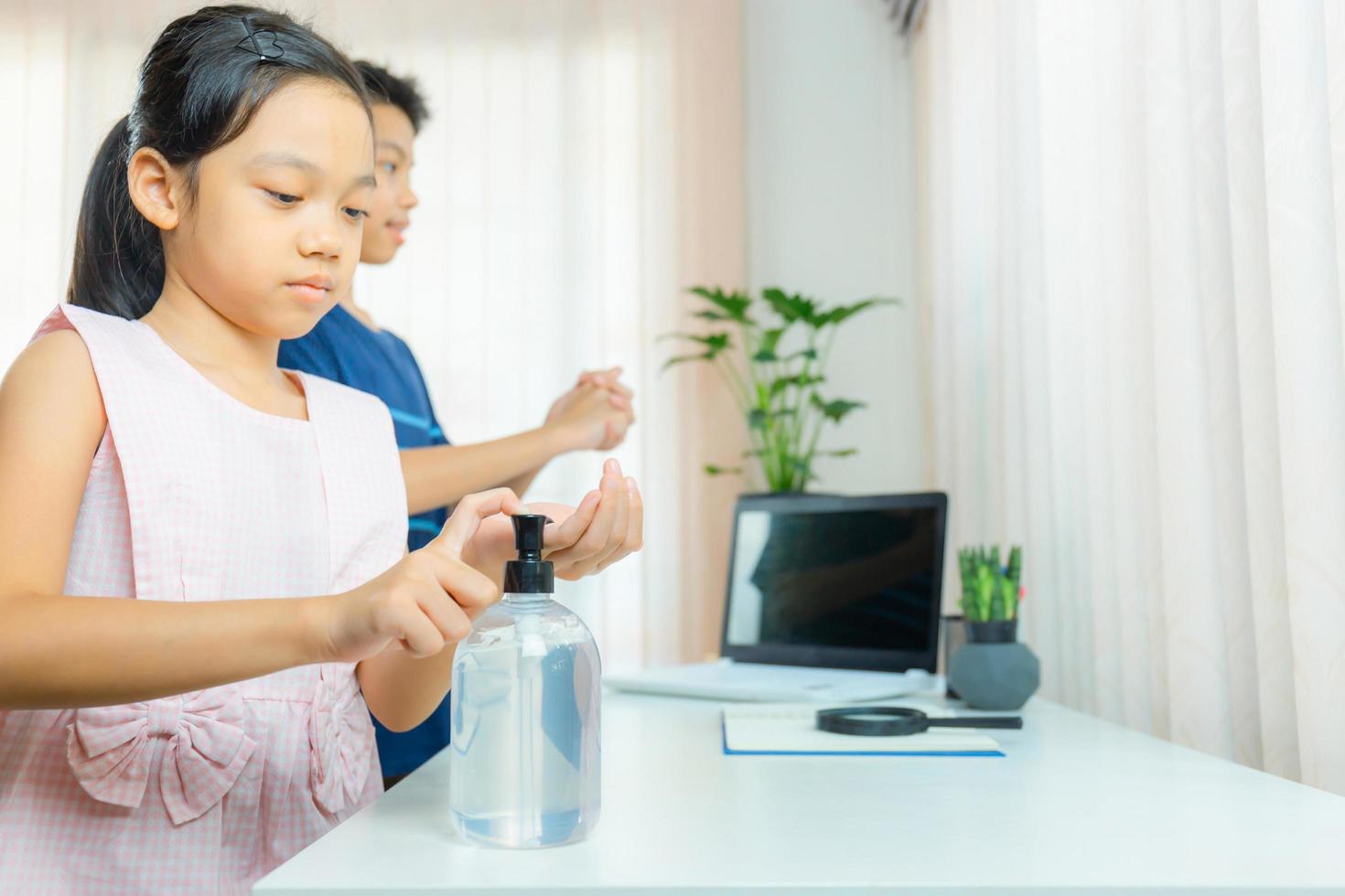bambini che si lavano le mani con gel alcolico o dispenser a pompa gel disinfettante per sapone antibatterico. concetto di igiene. foto