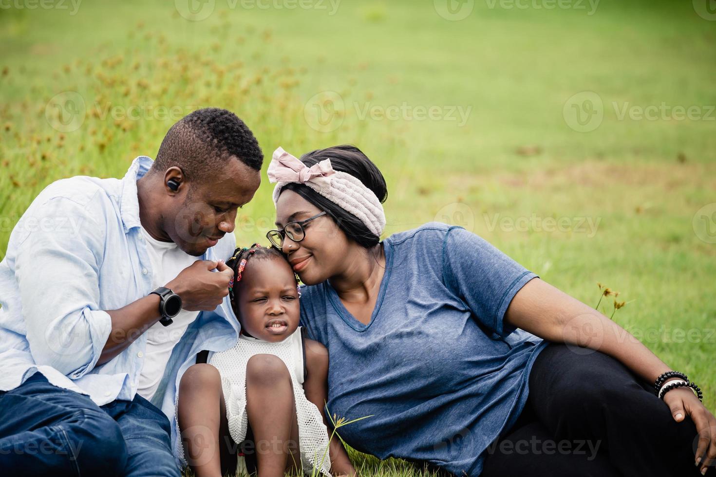 famiglia afroamericana che si diverte nel parco, padre felice madre e figlia che giocano insieme all'aperto, concetti familiari di felicità foto