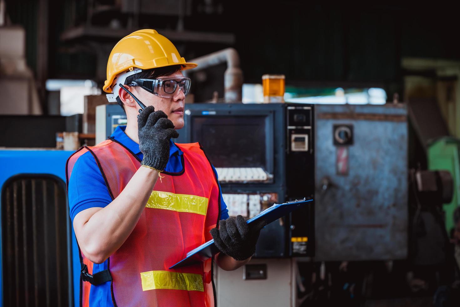 ingegneria industriale e lavoro di squadra che indossano controllo uniforme di sicurezza che opera la rettificatrice del tornio che lavora nella fabbrica industriale. foto