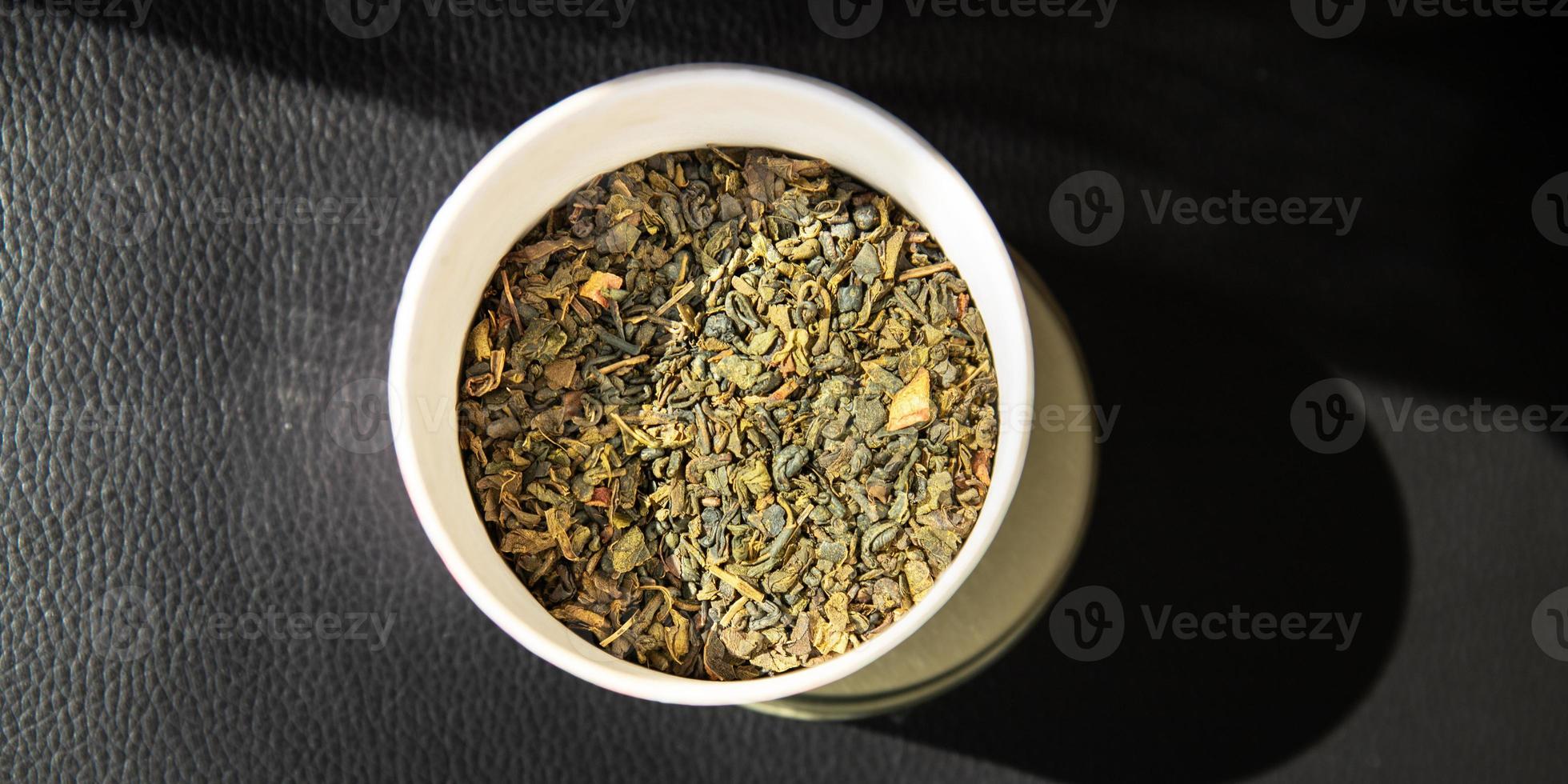 tè verde petali essiccati aromatizzato al tè spruzzato per preparare una bevanda calda foto