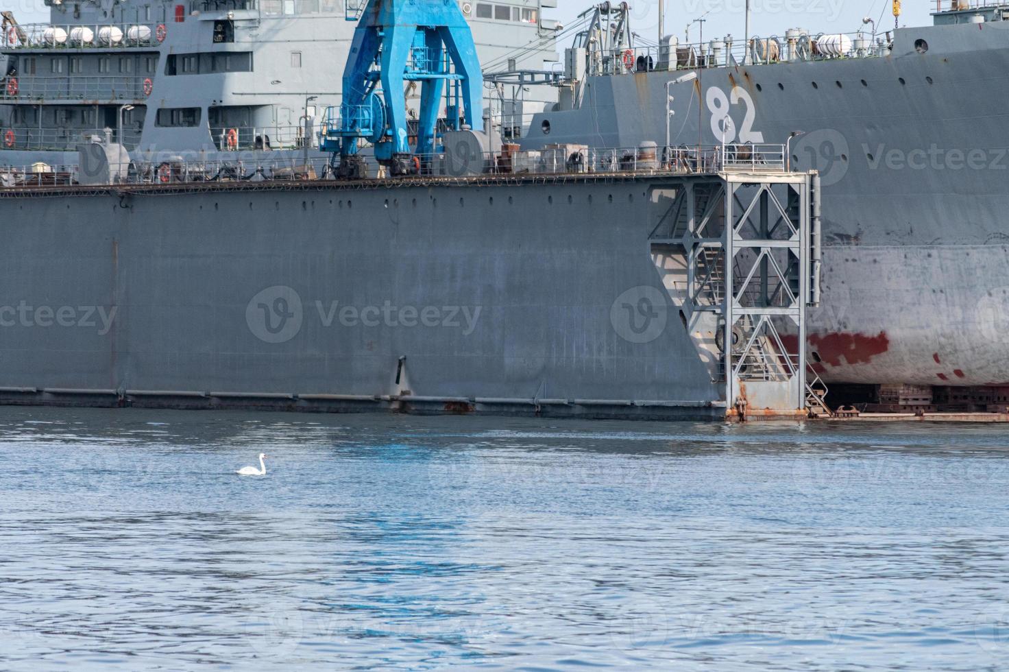 grandi navi della marina di ferro in cantiere per la riparazione. grande gru in cantiere. porto di mare blu foto