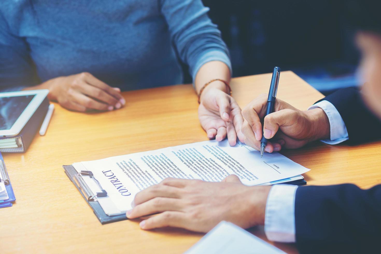 l'uomo d'affari firma il contratto durante una riunione di lavoro e passa denaro dopo le negoziazioni con i partner commerciali. messa a fuoco selezionata foto