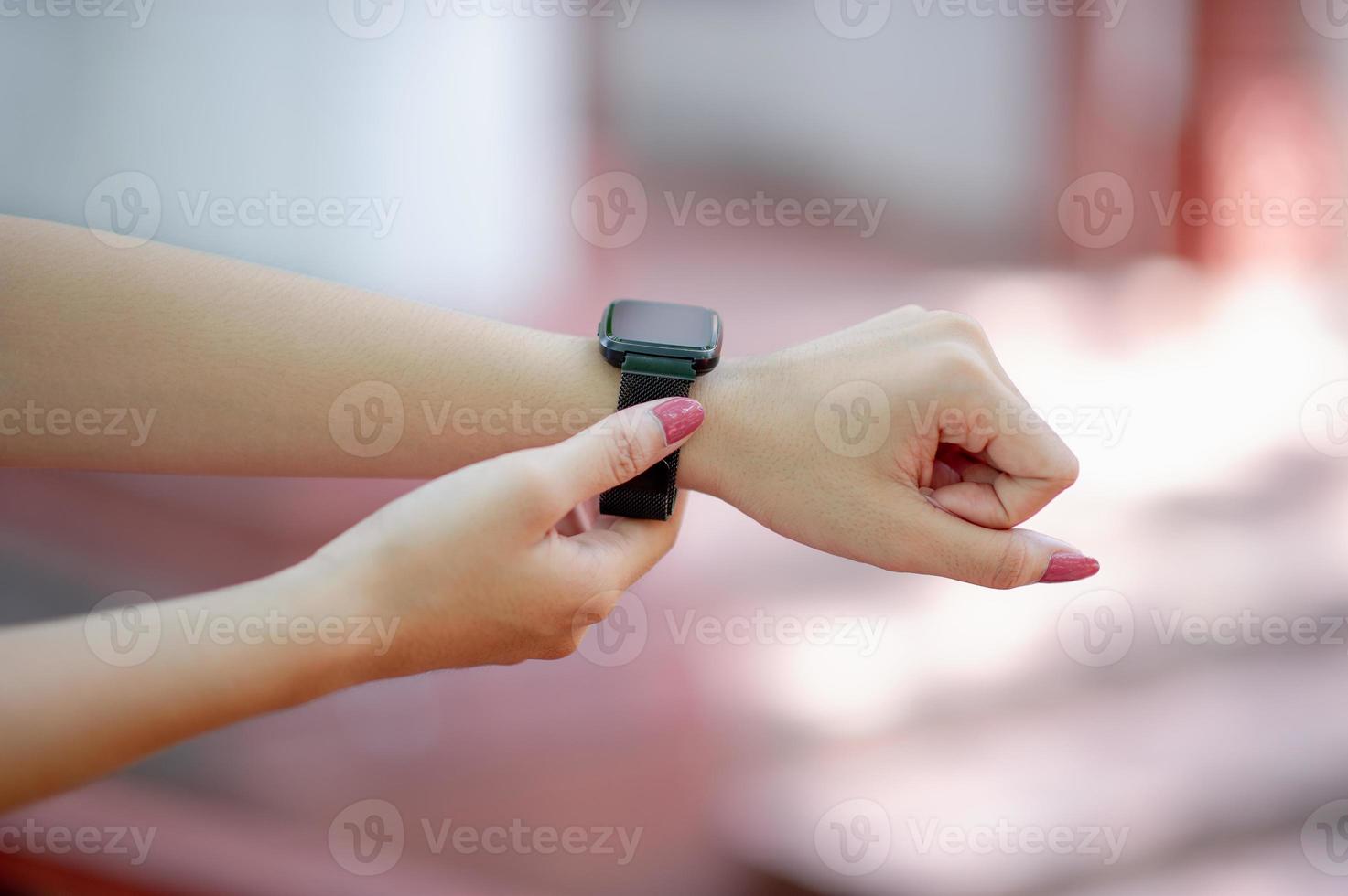 le sue mani e l'orologio da polso nero che conosce l'ora, il concetto, il tempo foto