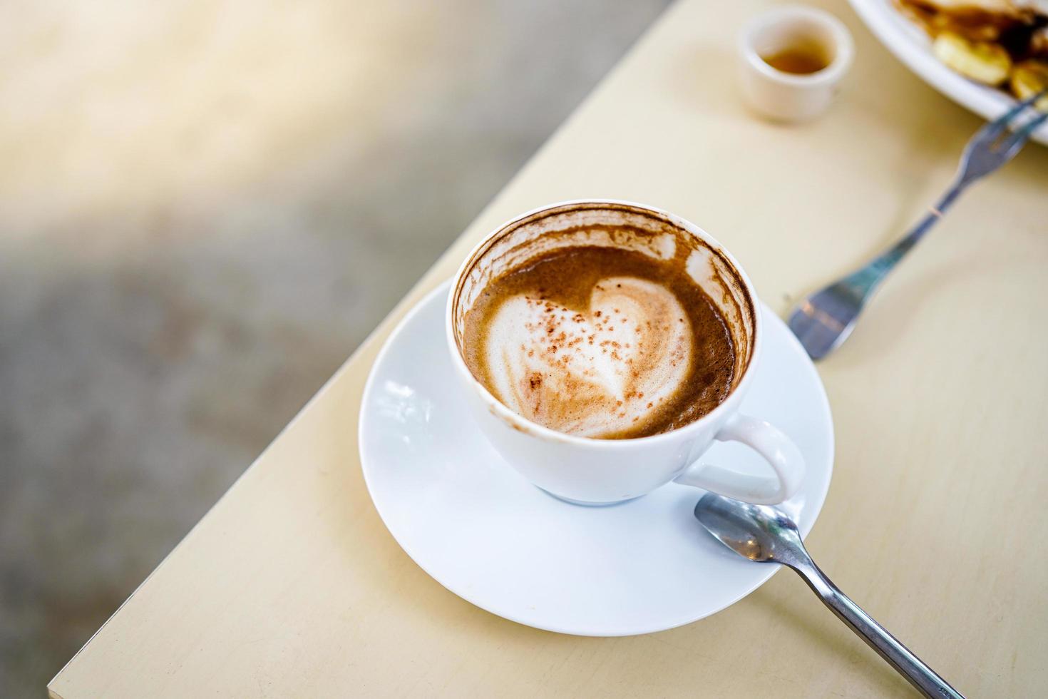 messa a fuoco selettiva, una tazza di caffè caldo latte con bella texture latte schiuma latte art su tavola di legno. vista dall'alto, copia spazio. pubblicità per il menu del bar. menù caffetteria foto