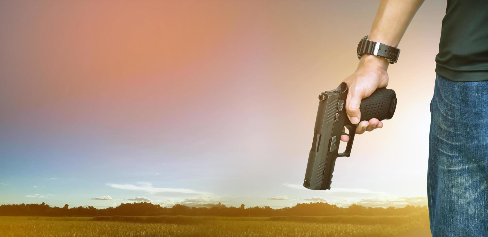 Pistola automatica da 9 mm che tiene nella mano destra del tiratore, concetto di sicurezza, rapina, gangster, guardia del corpo in tutto il mondo. messa a fuoco selettiva sulla pistola. foto