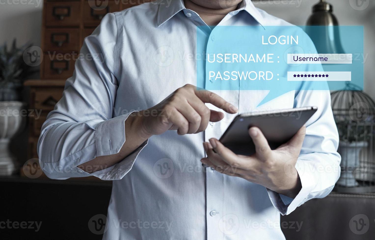 uomo d'affari in possesso di un tablet con una schermata di accesso, inserire nome utente e password. foto