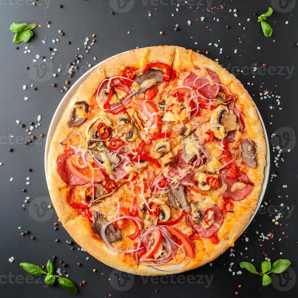 pizza italiana su sfondo scuro, vista dall'alto foto
