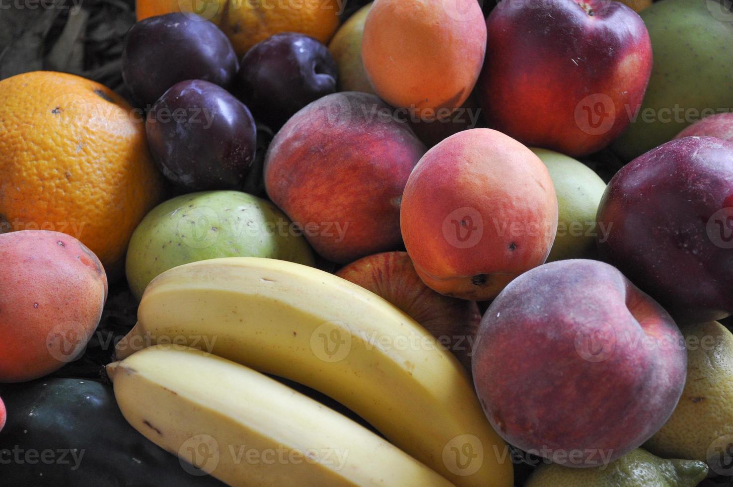 molti frutti diversi tra cui pesca banana pera mela prugna an foto