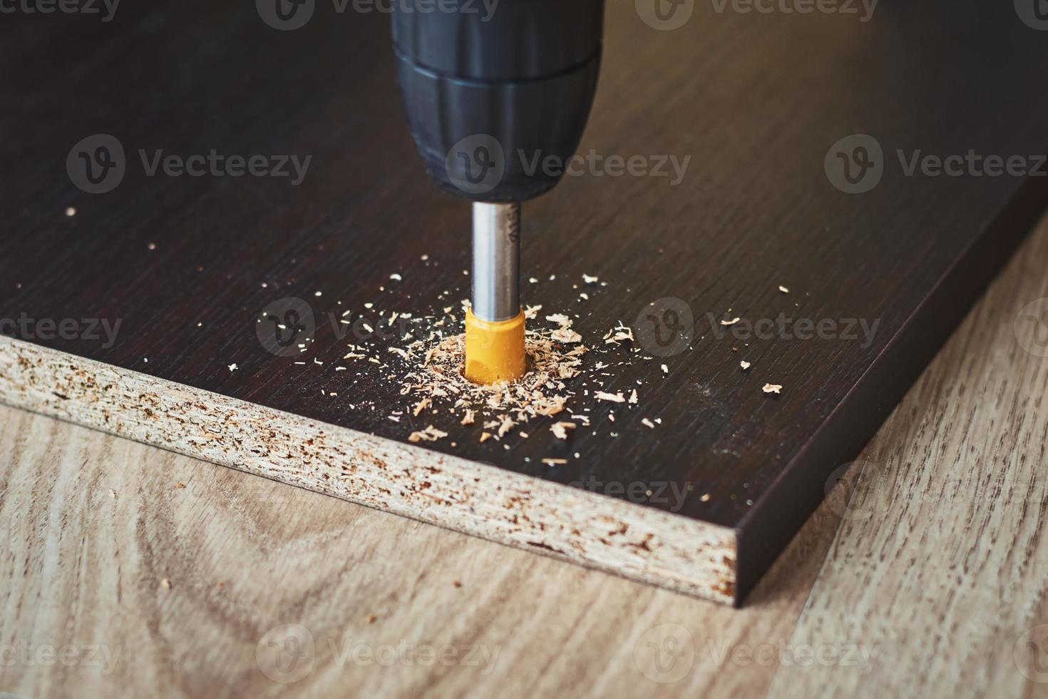 processo di perforazione del legno con una punta da trapano da vicino foto
