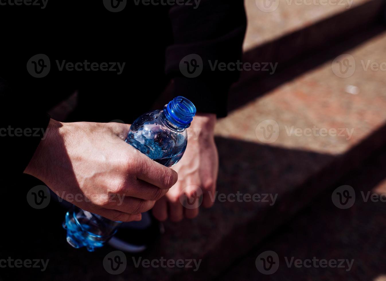 mano che tiene una bottiglia blu foto