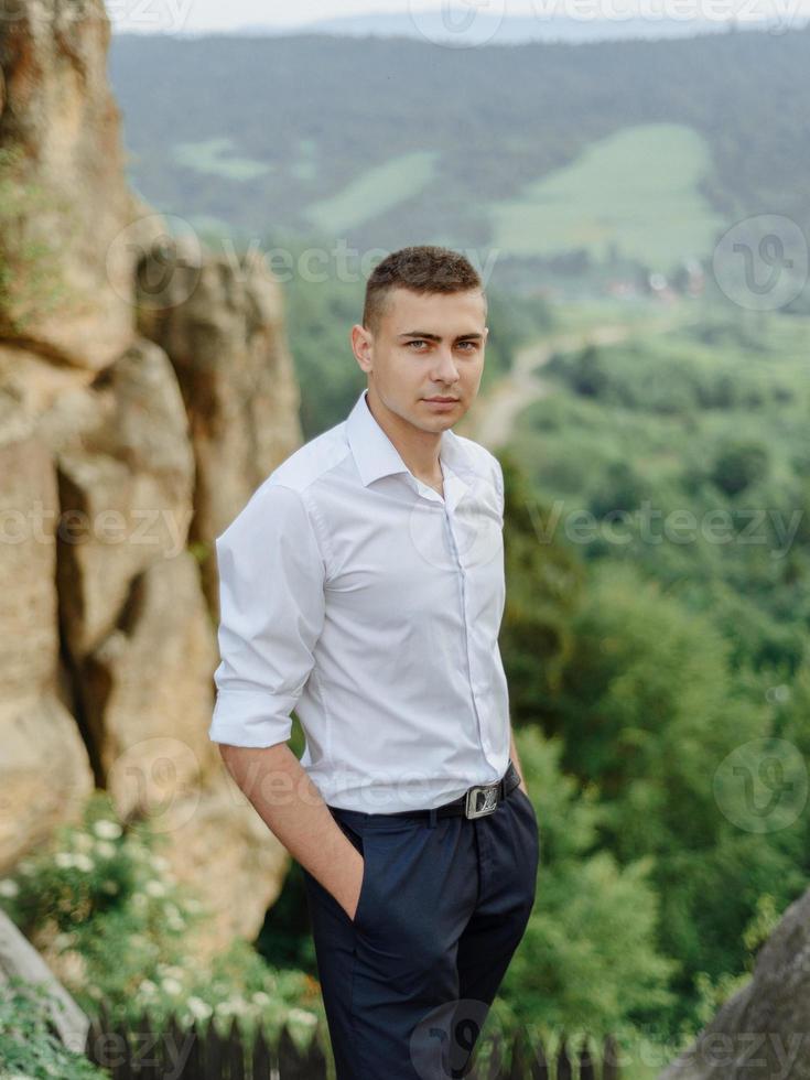 ritratto di un giovane sposo girato in montagna foto