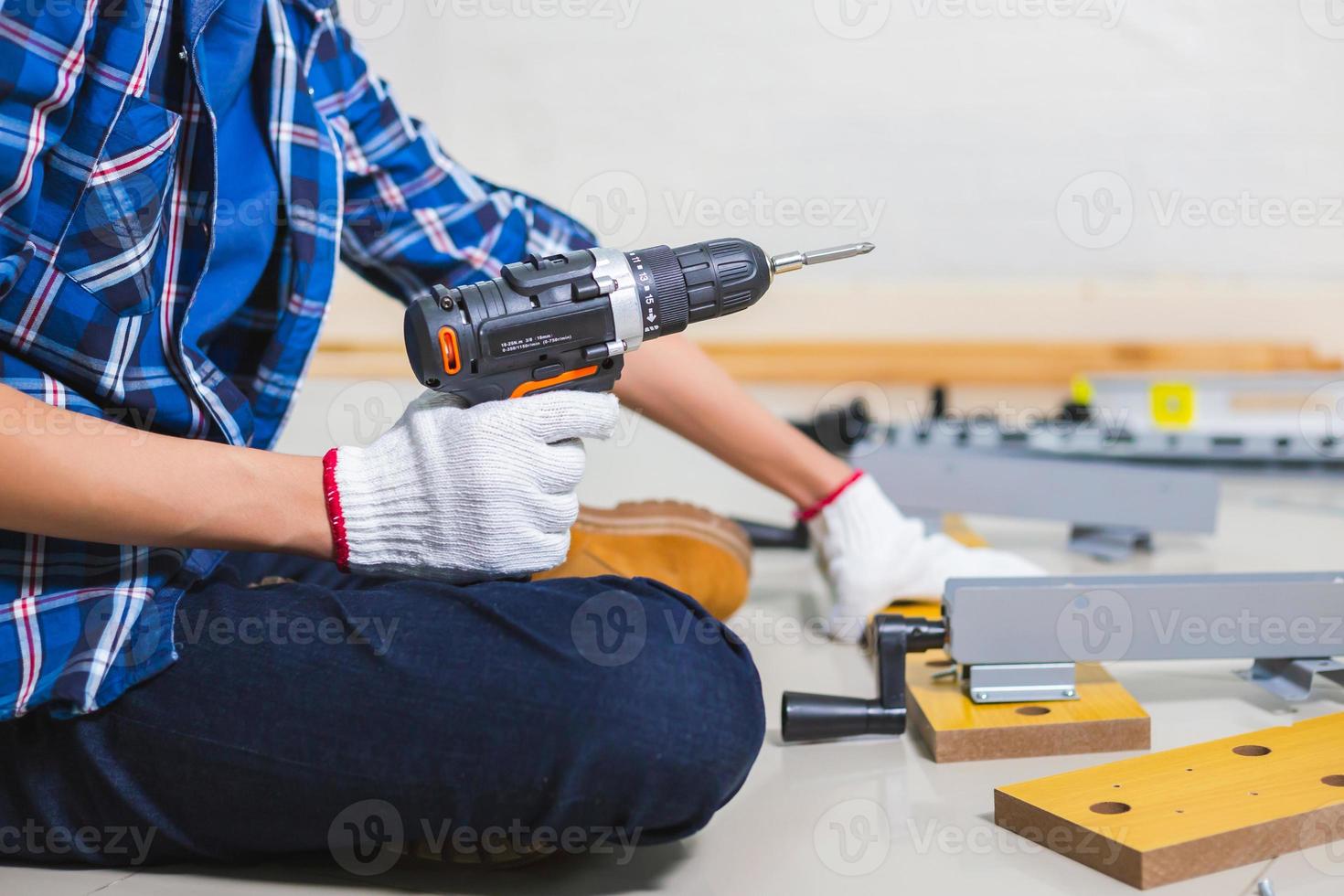 assemblare mobili. uomo con trapano avvitatore elettrico assemblaggio mobili, artigiano con trapano avvitatore elettrico foto