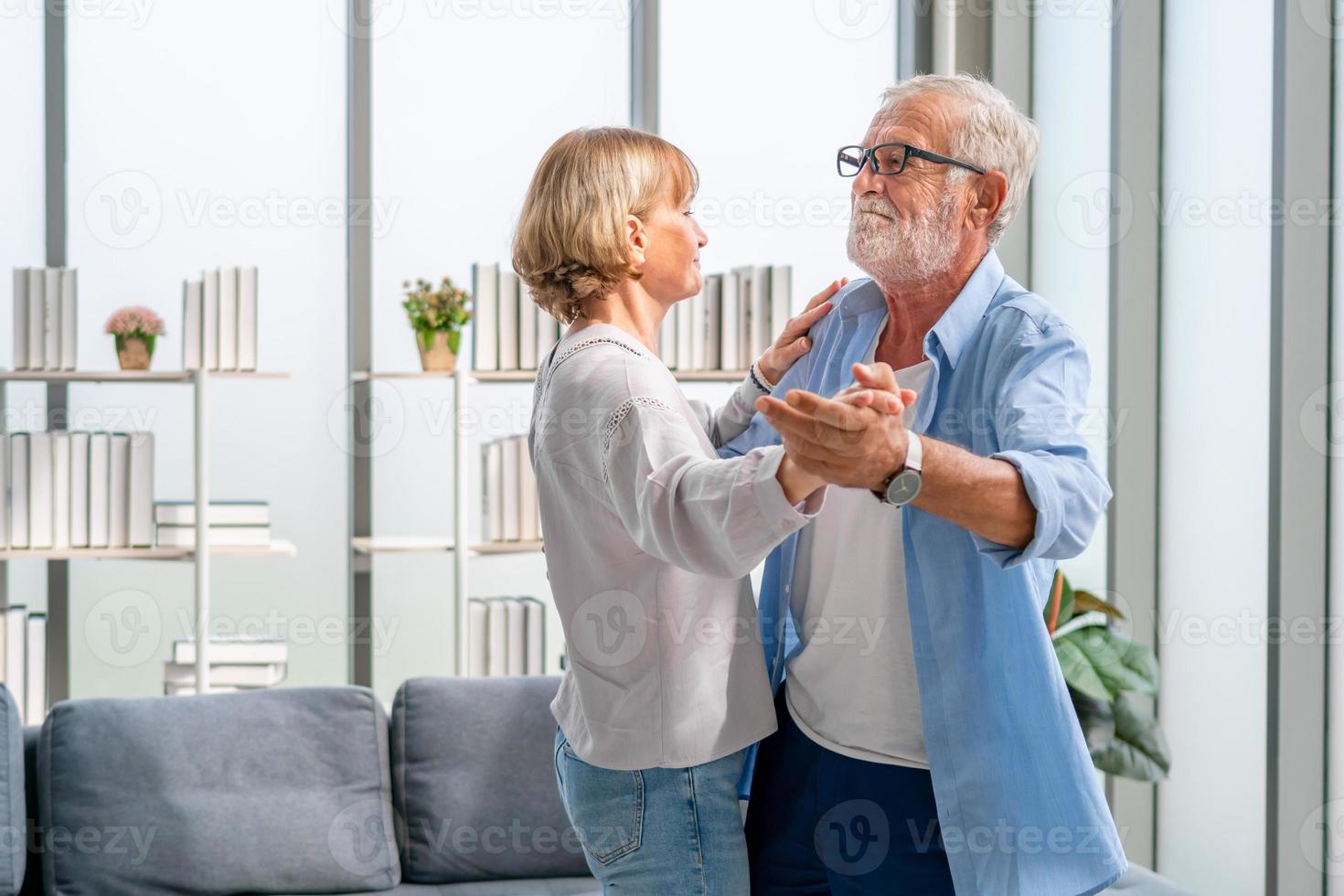 ritratto di felice coppia senior che balla in soggiorno, donna anziana e un uomo che balla, concetti di famiglia felice foto