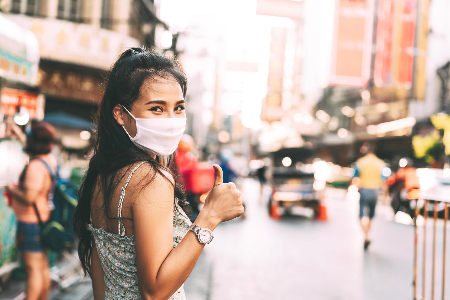 felice donna asiatica adulta pelle abbronzata indossare maschera sul viso per una nuova normalità. foto