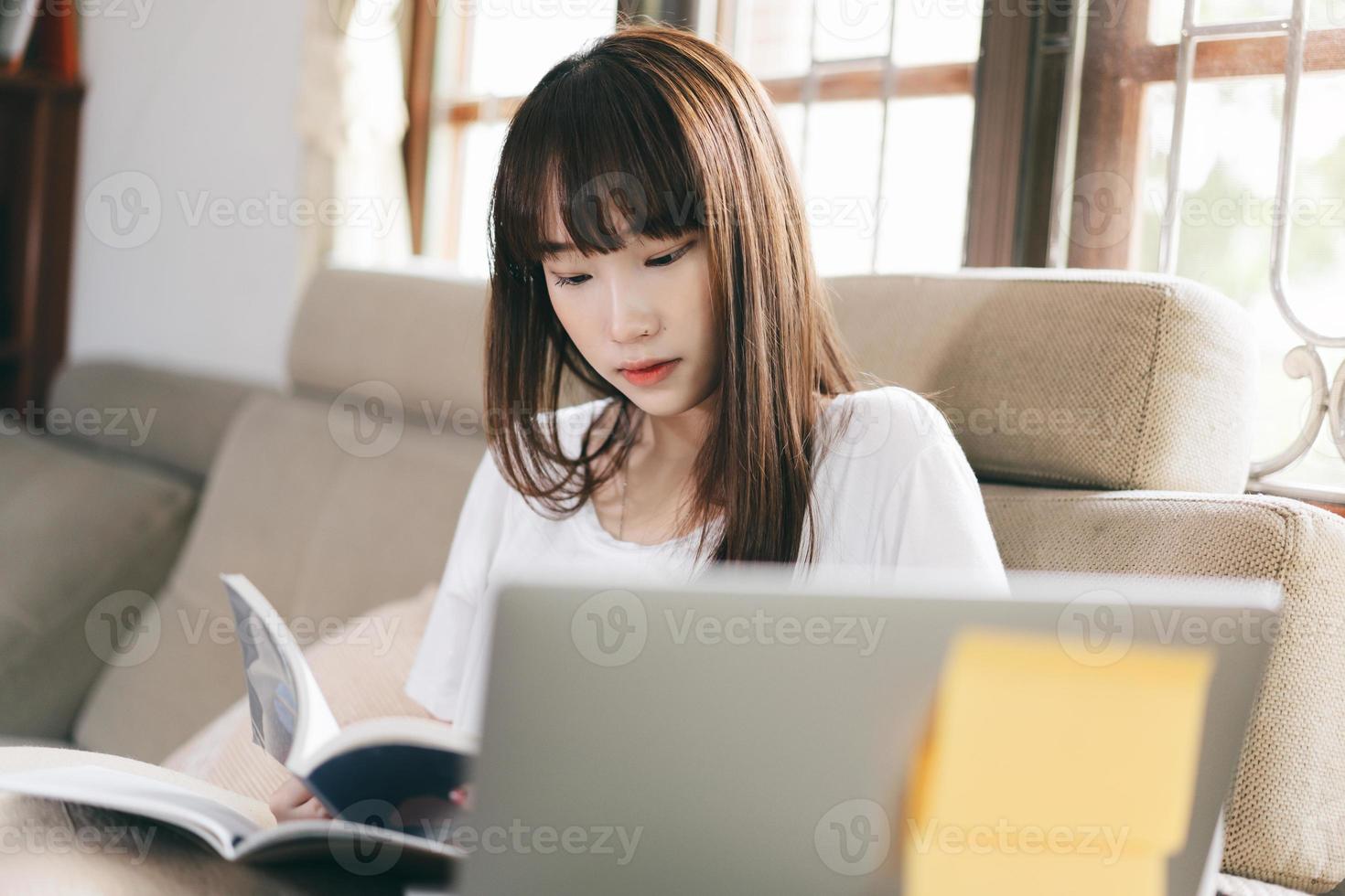 la donna asiatica dell'adolescente di sorriso felice studia online e resta a casa. foto