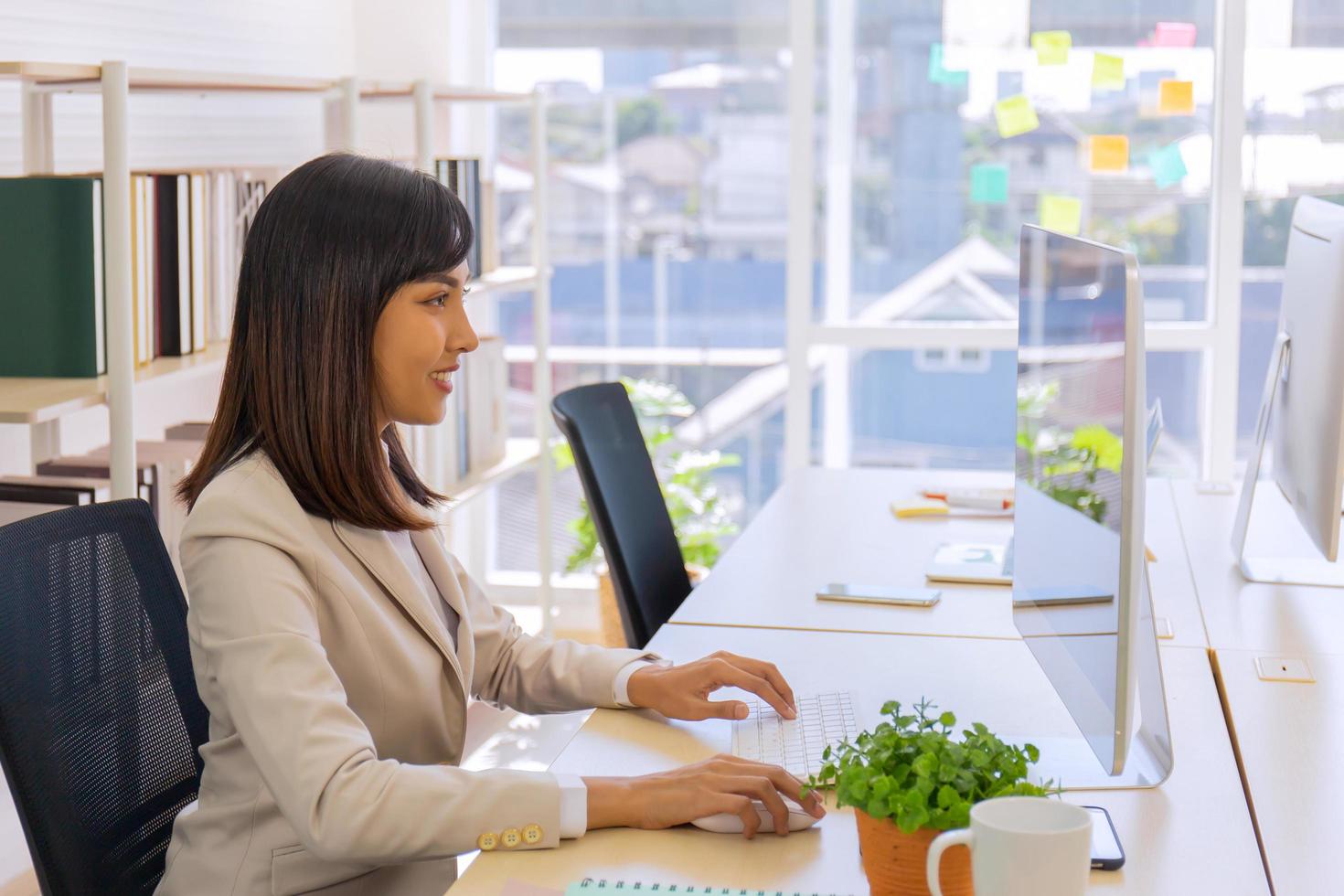 le donne d'affari asiatiche si siedono e lavorano in ufficio con diligenza, determinazione foto