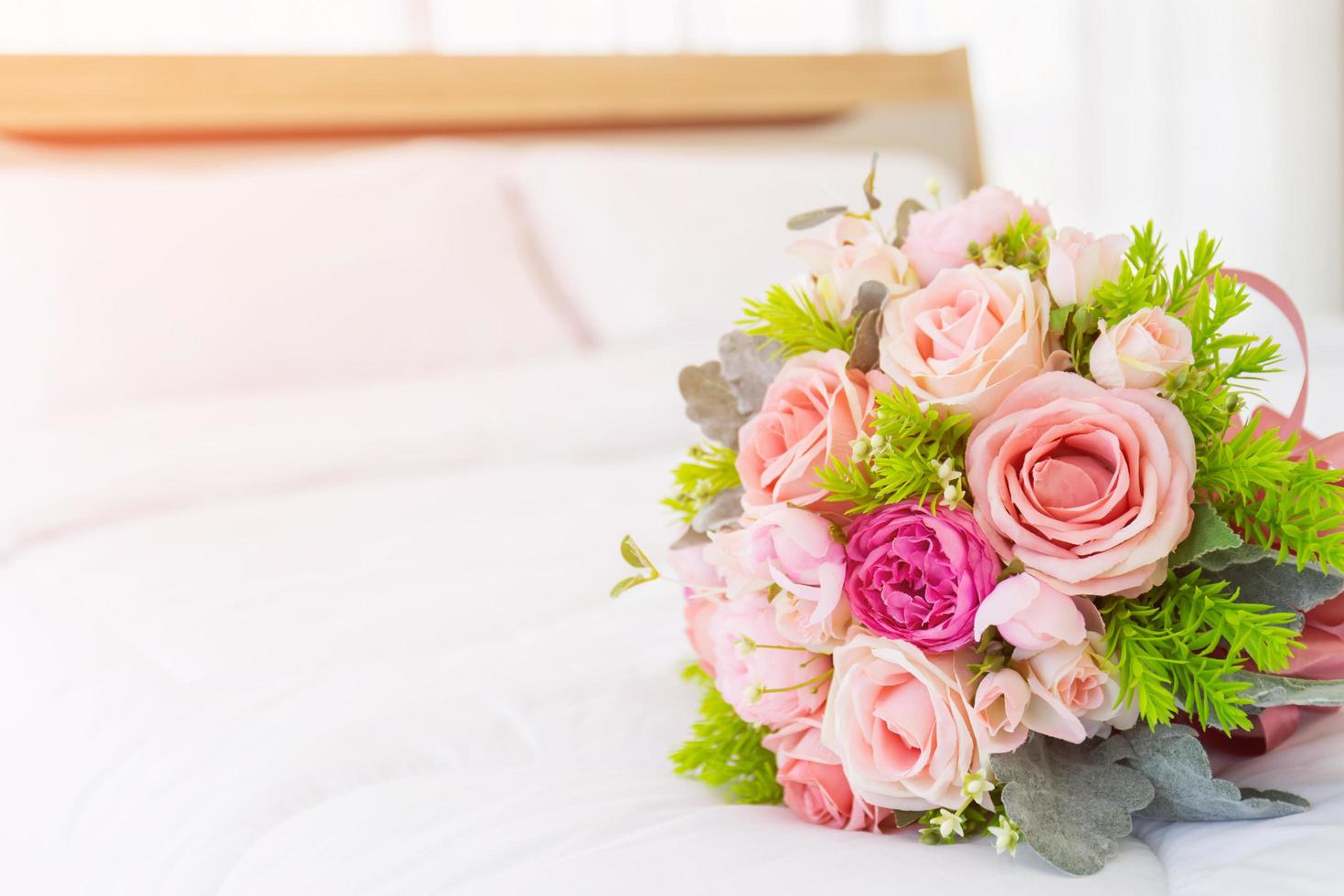 bellissimo bouquet di fiori adagiato su un letto bianco pulito. foto