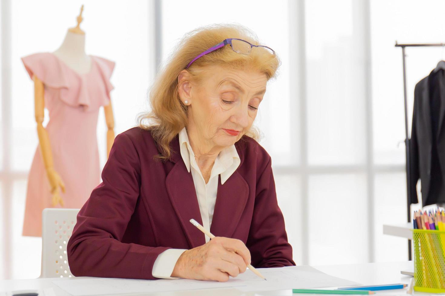 designer femminili professionisti stanno disegnando schizzi su carta nell'ufficio di un negozio di cucito. foto