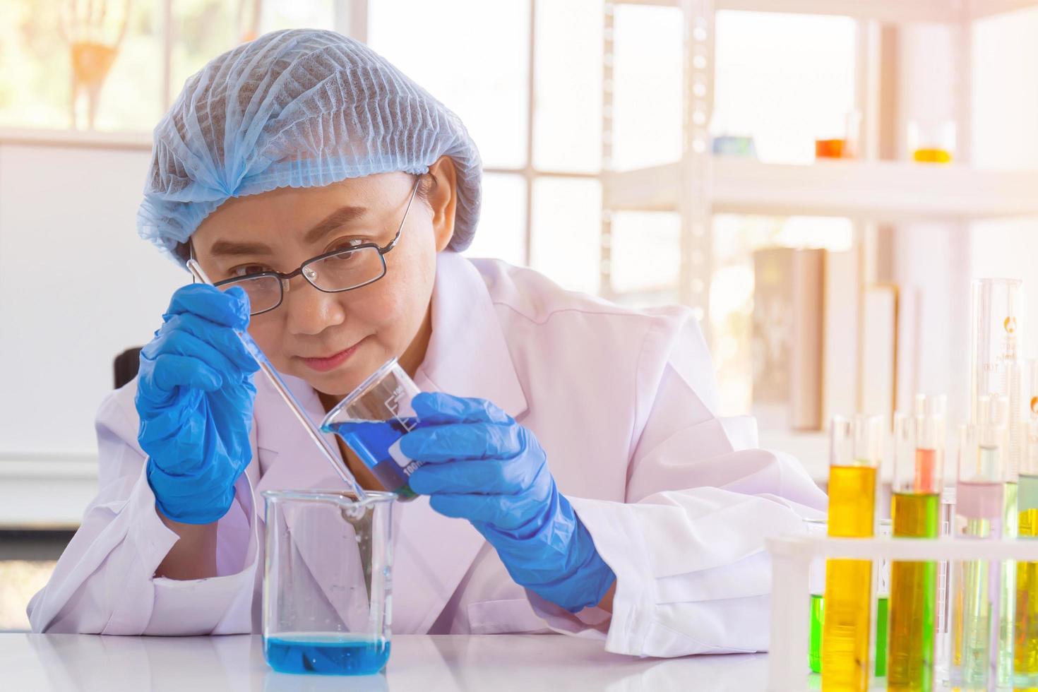 una scienziata asiatica sta ricercando una formula chimica in un laboratorio. foto
