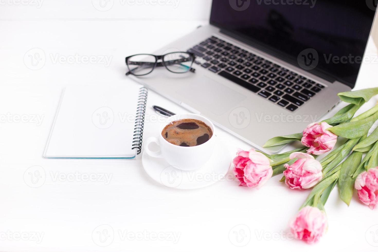 tulipani rosa con un'atmosfera festosa e caffè su tavole di legno bianche. foto