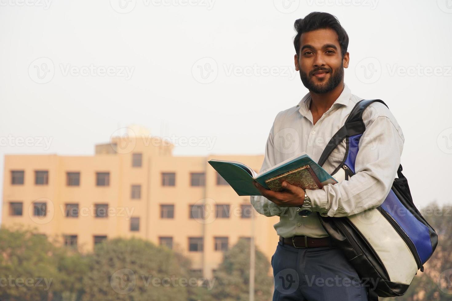 studente indiano con libri e borsa al campus universitario foto