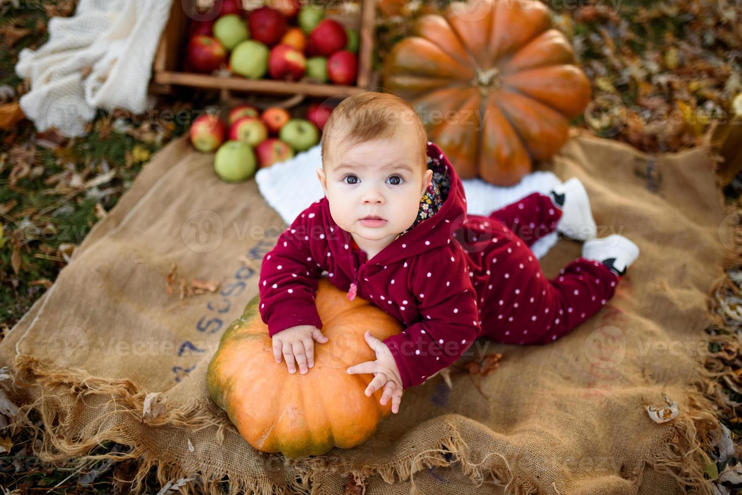 la bambina si appoggia su una zucca. foto