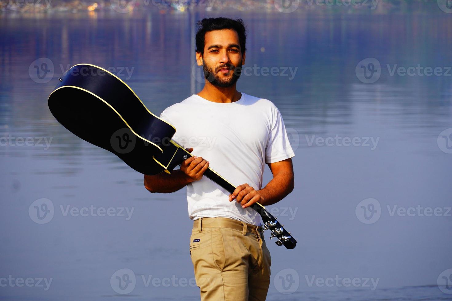 uomo che suona la chitarra acustica sulla barca. foto