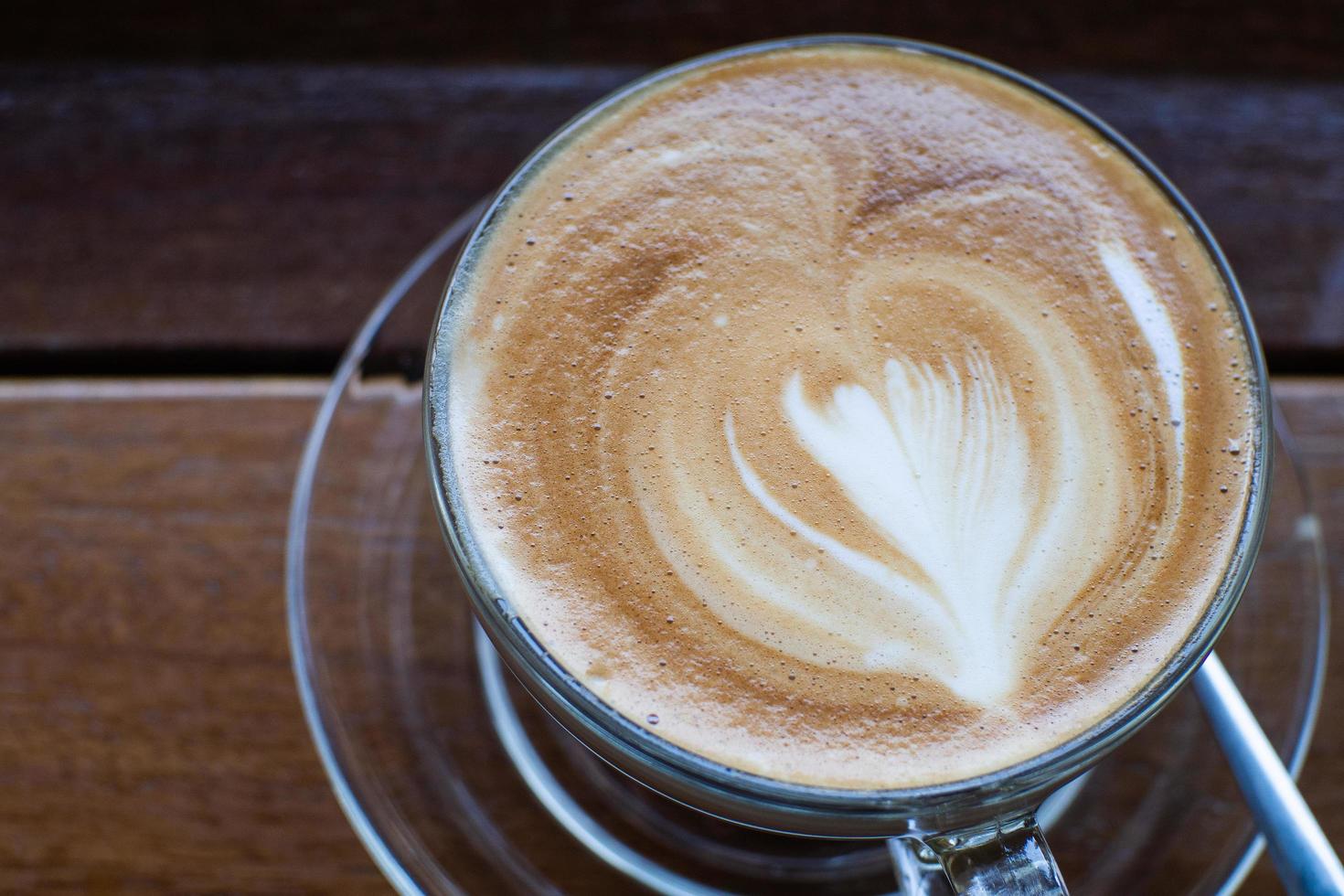 cappuccino sul vecchio tavolo di legno e chicchi di caffè tostati - immagine foto