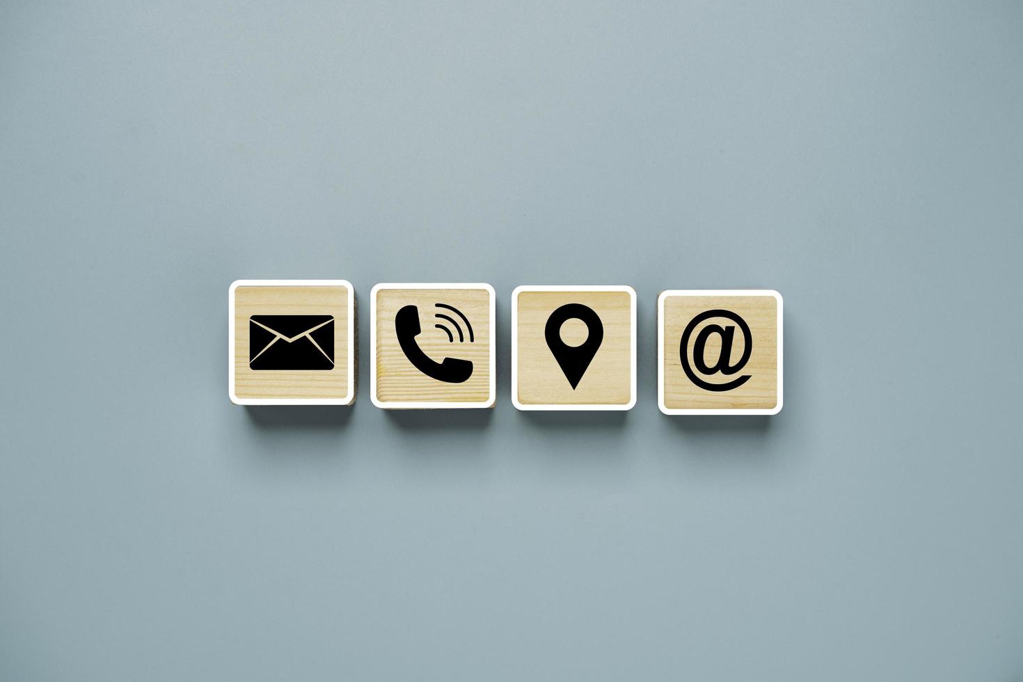 nero lettera telefono posizione e indirizzo icone stampa schermo su blocco cubo di legno per il concetto di contatto del servizio clienti. foto