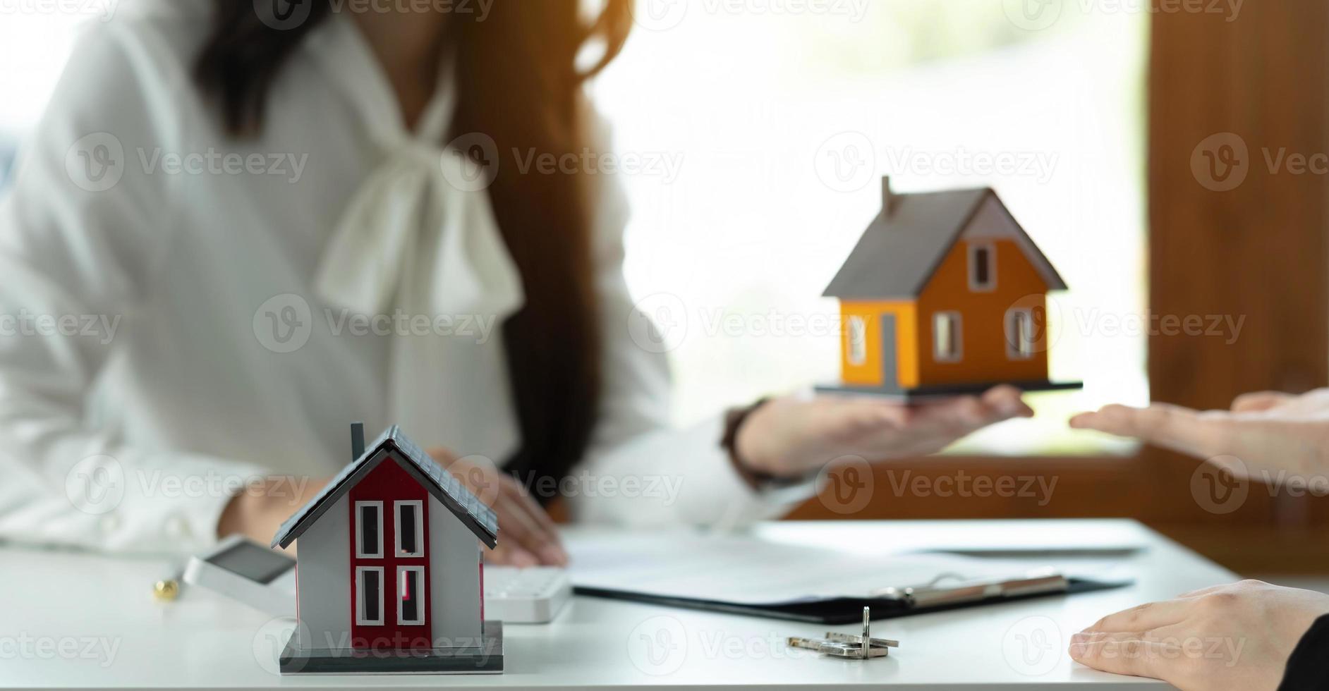 modello di casa con agente e cliente che discutono per l'acquisto di un contratto, l'assicurazione o il prestito di immobili o proprietà. foto