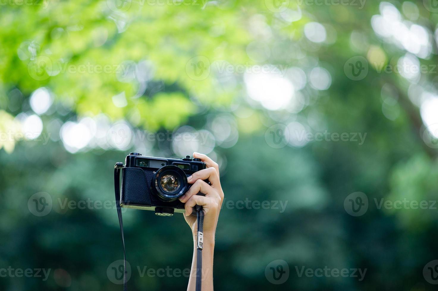 fotografo e amante della fotocamera fotocamera nera e sfondo verde naturale foto