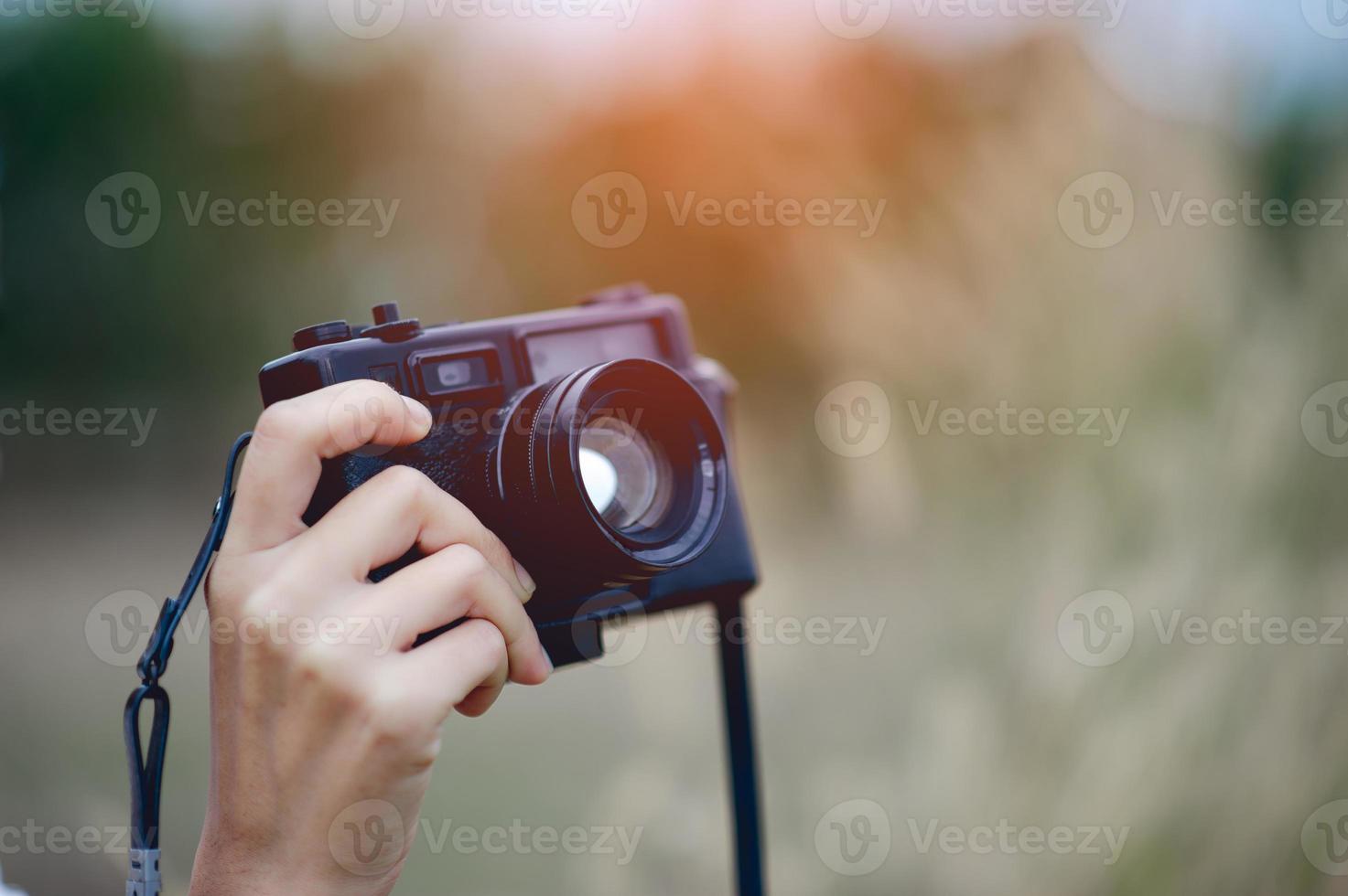 mano e fotocamera del fotografo che tiene e trasporta la fotocamera per scattare foto