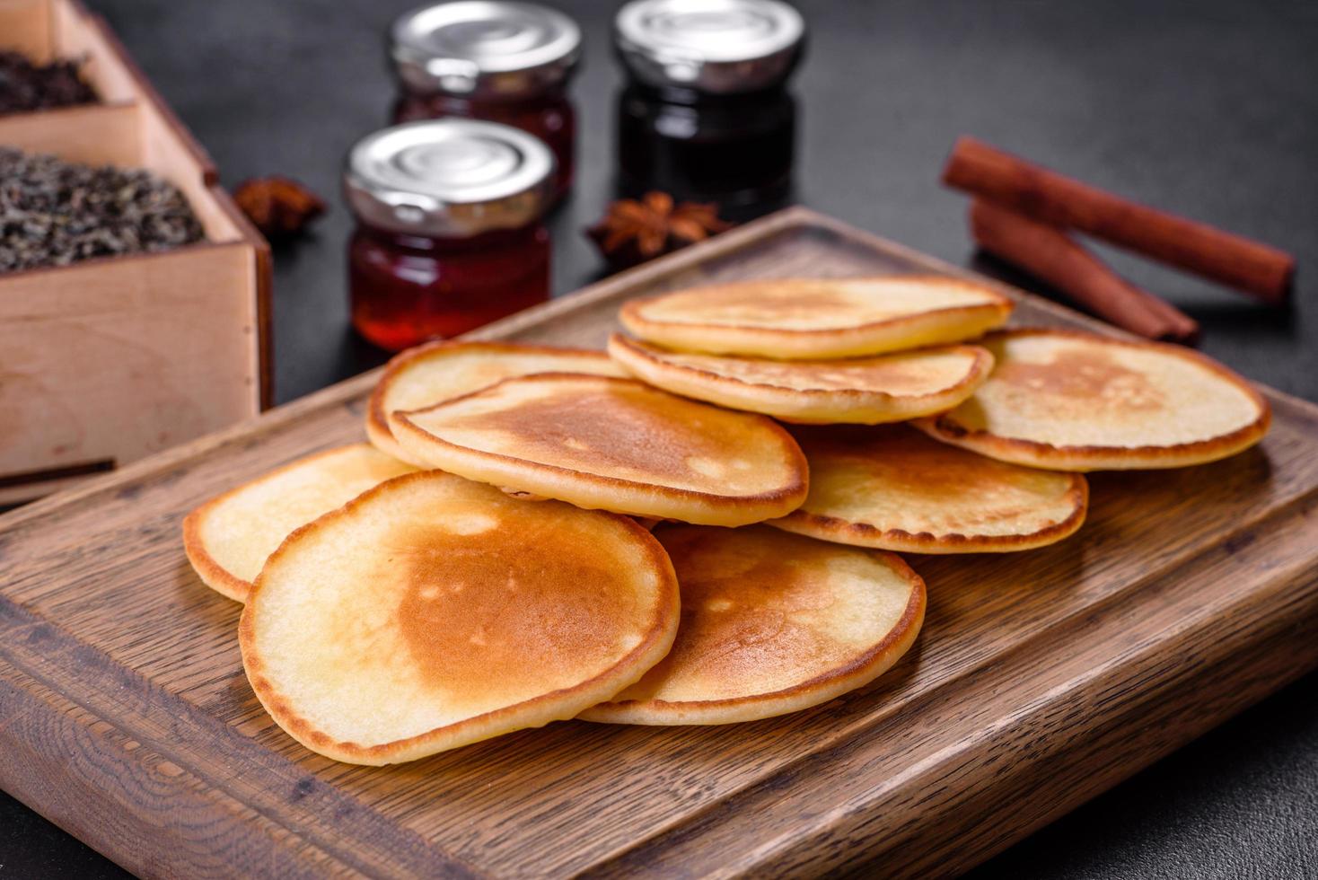 frittelle fresche deliziose su un tagliere di legno con zucchero foto