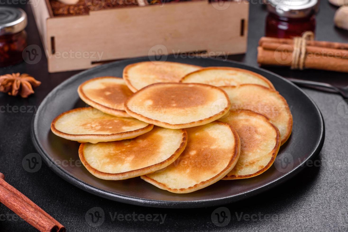 frittelle fresche deliziose su un tagliere di legno con zucchero foto