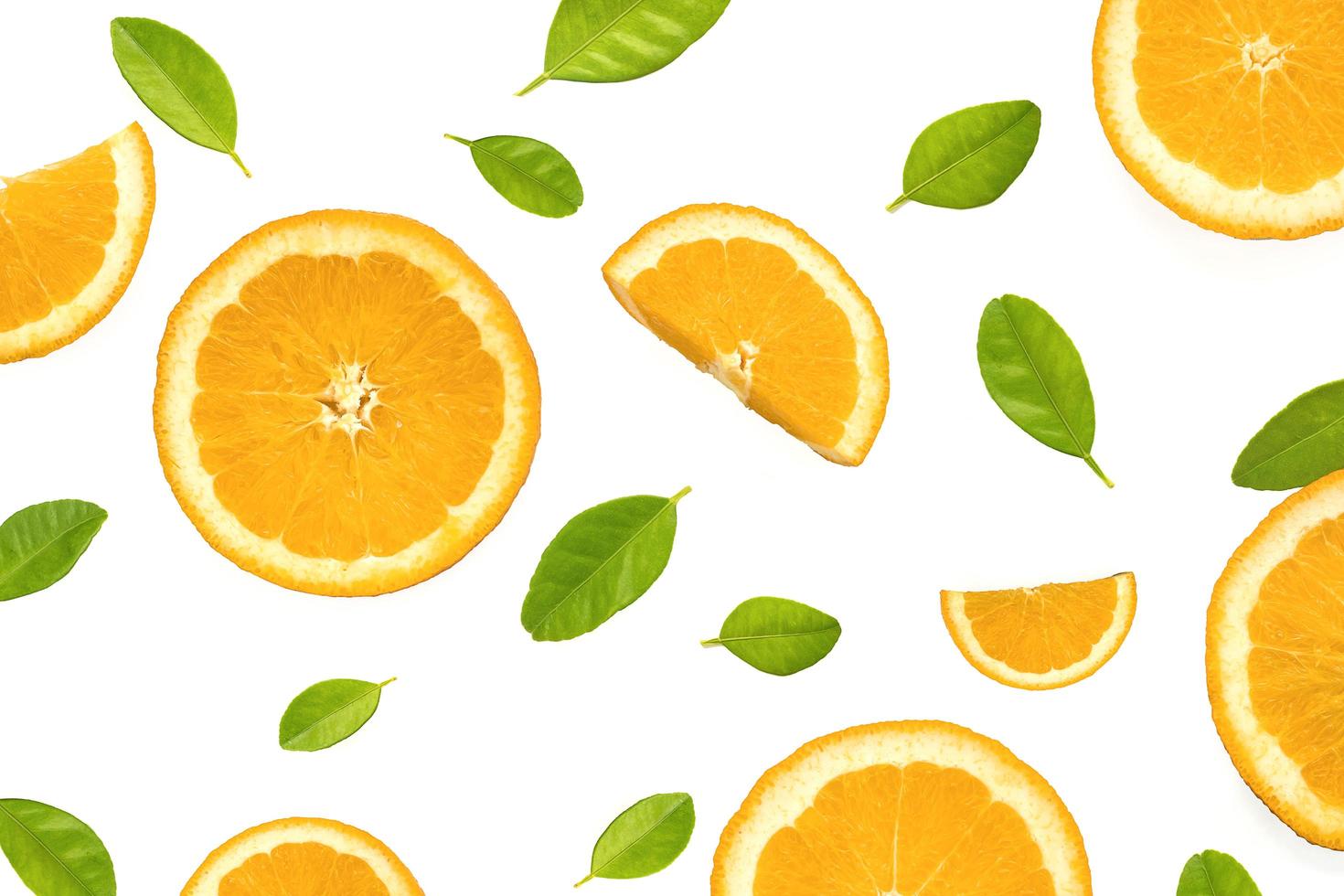 disposizione piatta di fette d'arancia con foglie verdi su sfondo bianco foto