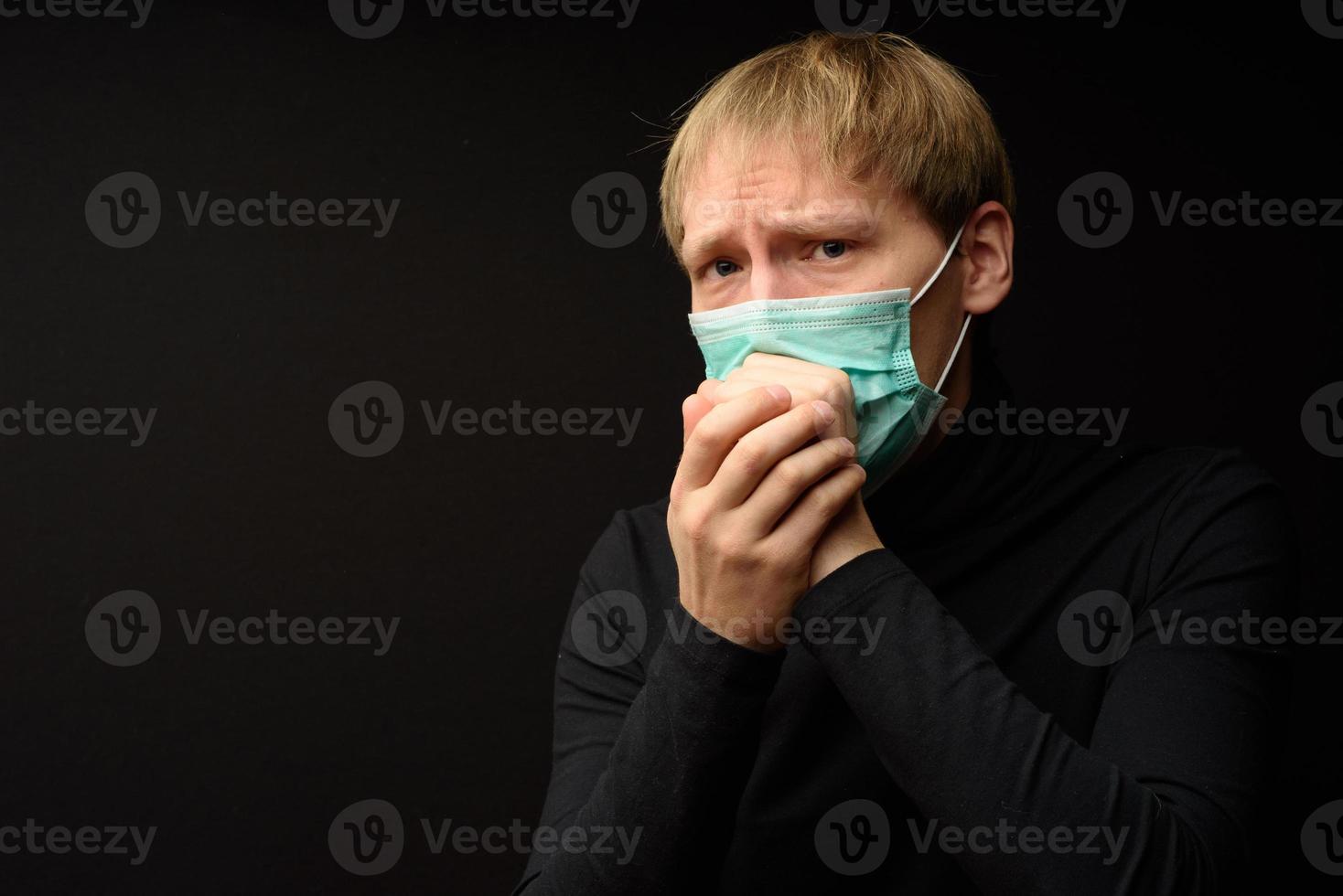 l'uomo di mezza età con il ritratto della maschera medica da vicino illustra la malattia del coronavirus pandemico su sfondo scuro. concetto di contaminazione da focolaio di covid-19. foto