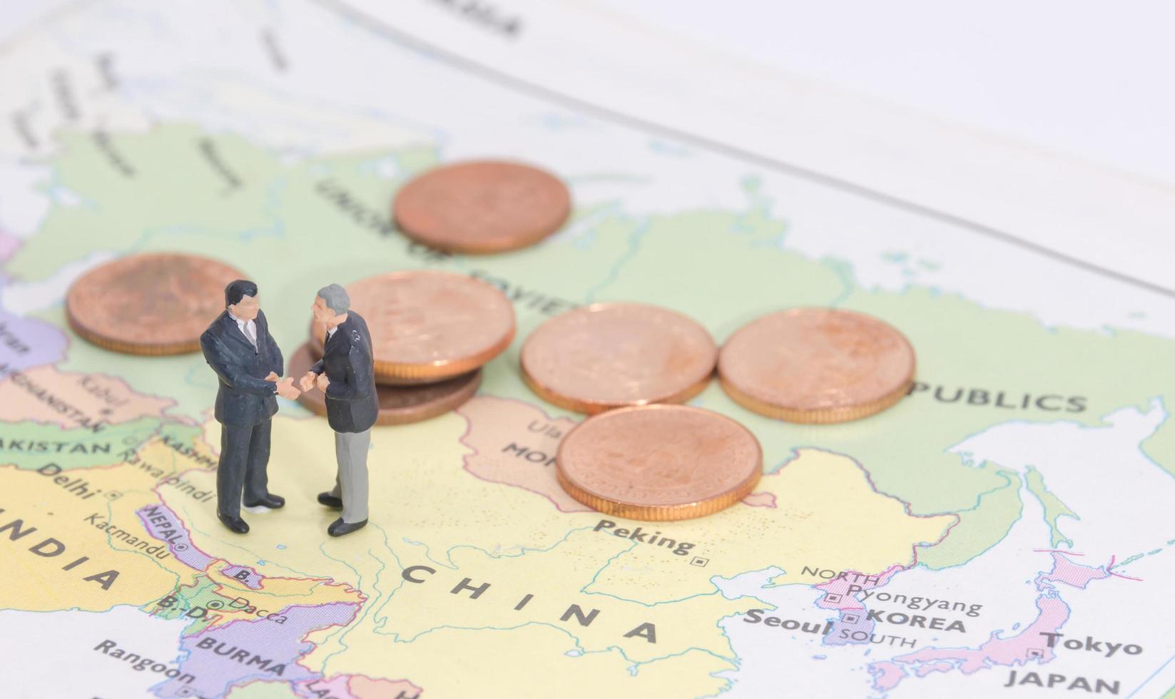 in miniatura due uomini d'affari shakehand sulla mappa della cina foto