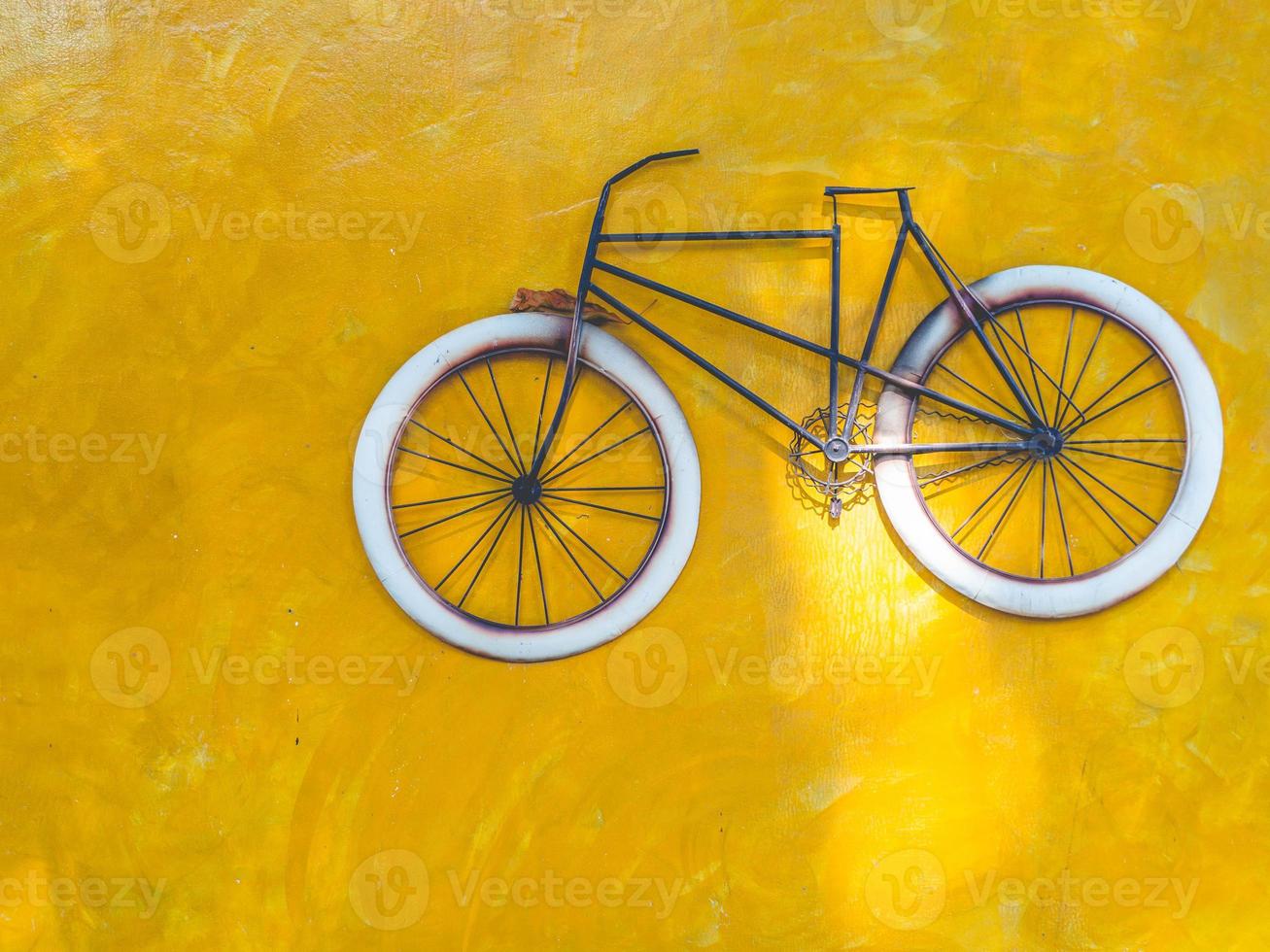 bicicletta e muro giallo foto