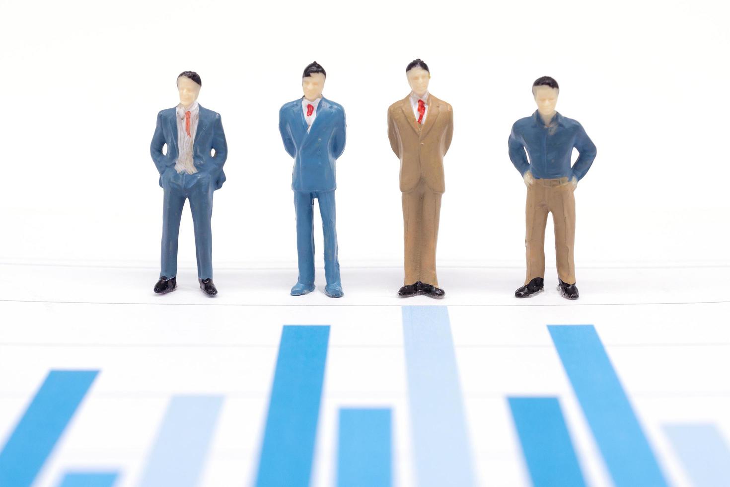 figure in miniatura uomini d'affari in piedi su un grafico grafico finanziario foto