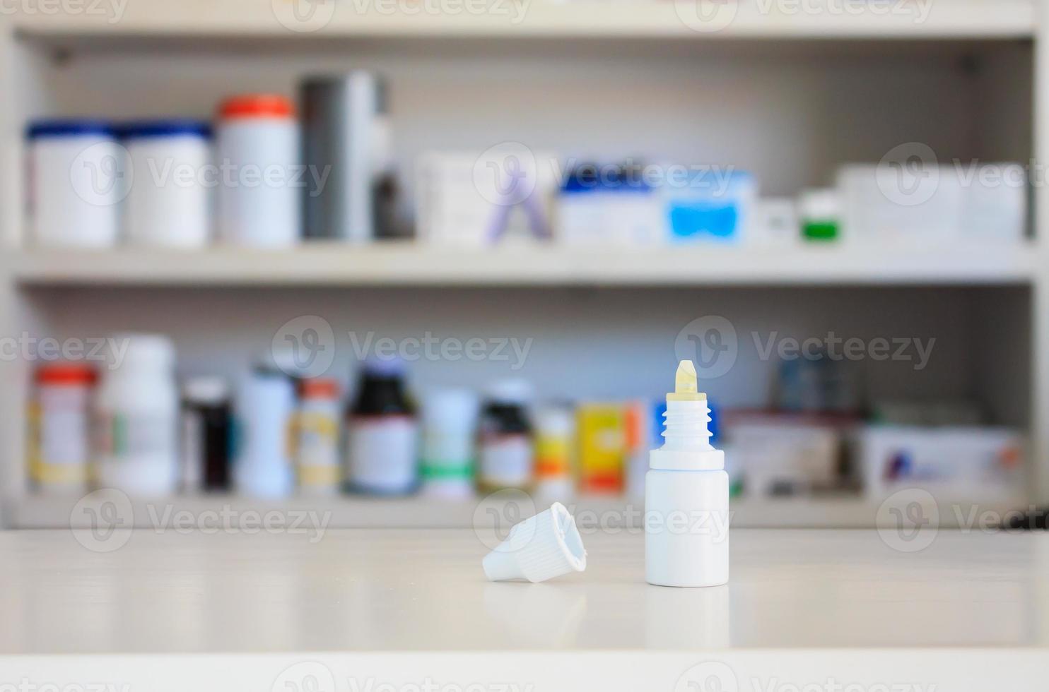gocce per le orecchie bottiglia di medicina con sfondo di scaffali di negozi di farmacia foto