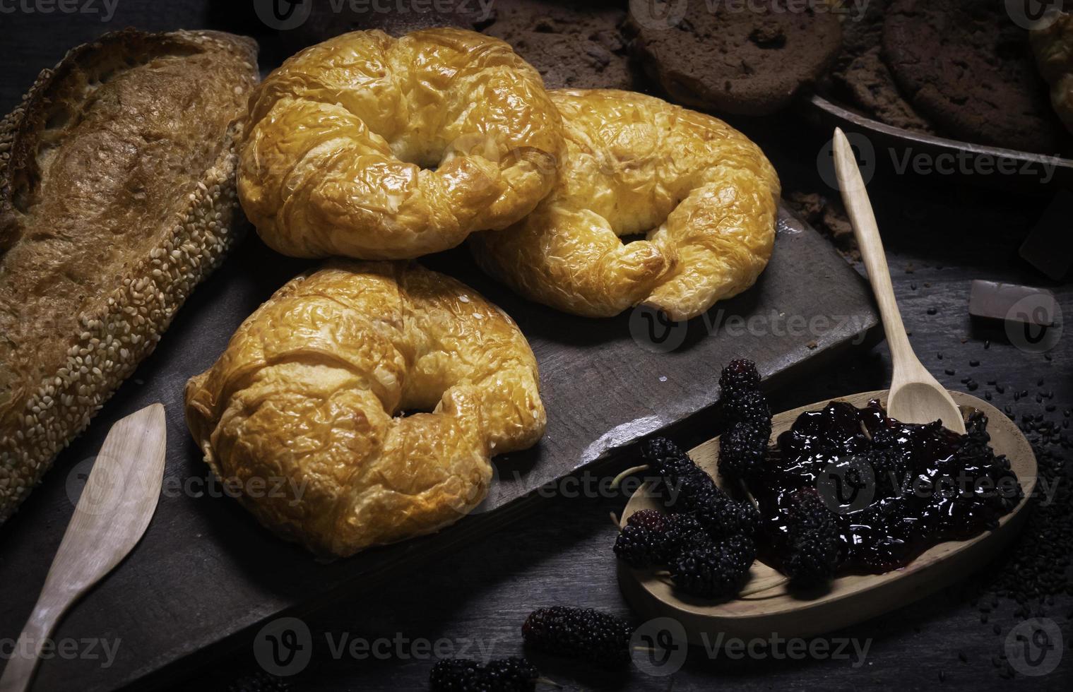 dolci da forno popolari come croissant, biscotti in idee per apparecchiare la tavola per dessert o cottura. pasticceria da forno con marmellata di frutti di bosco, mandorle e semi di papavero. foto