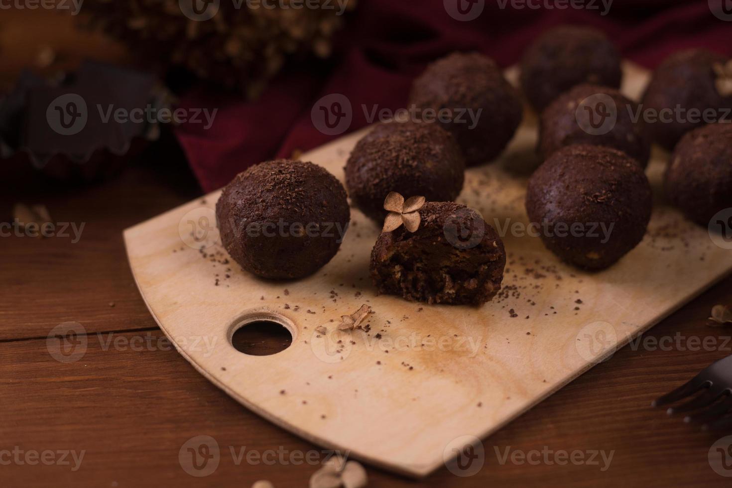 palline di cacao, torte al tartufo di cioccolato a bordo su fondo di legno foto